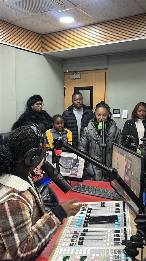 Nyangu young authors and staff gathered around the EBIS Radio presenter's desk