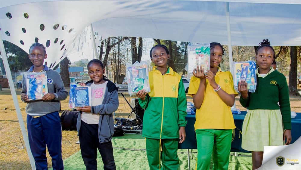 Young authors lined up on stage holding the book prizes they won