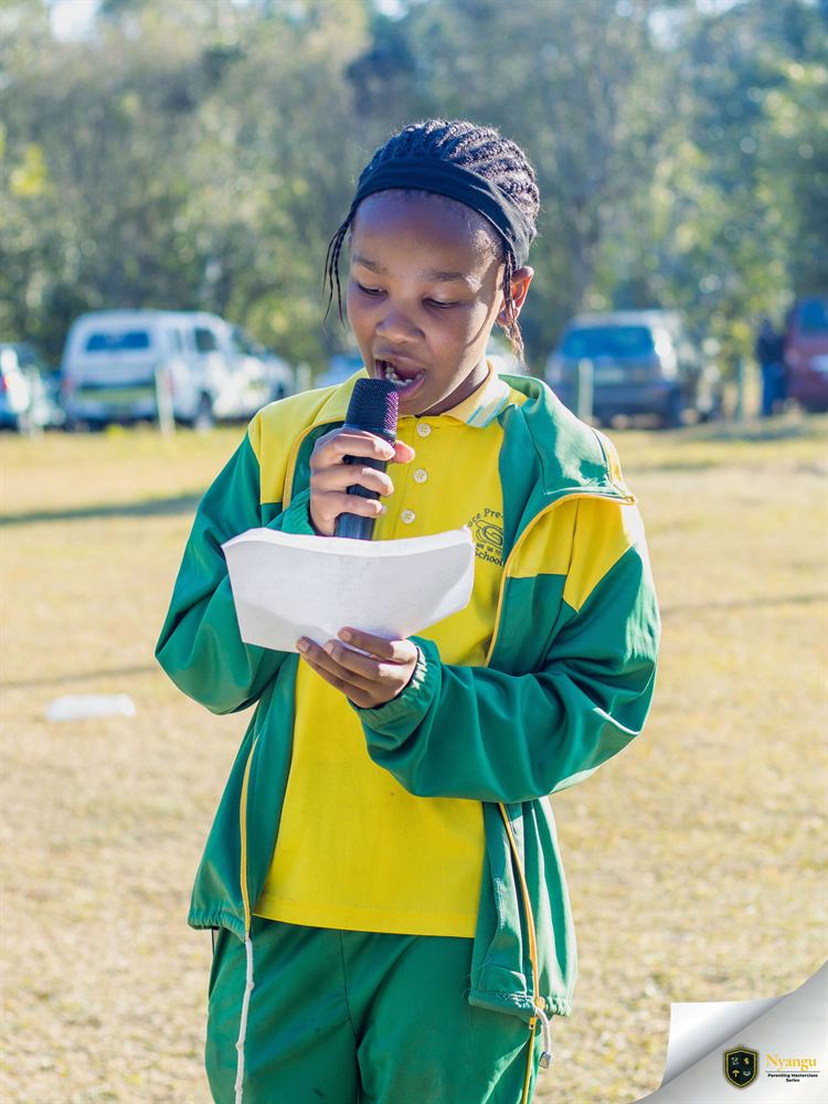 A young author reading her story aloud into the microphone
